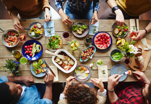 People Sitting Around Wood Table Eating