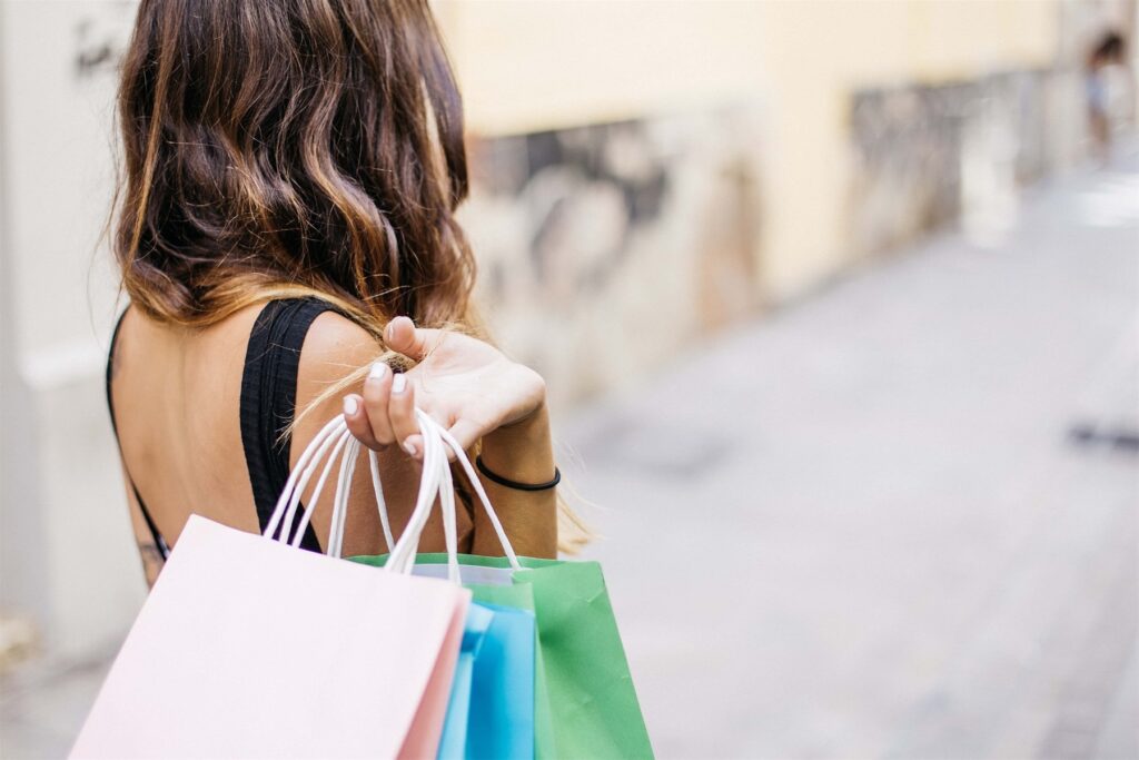 Women Holding Shopping Backs Over Her Shoulder